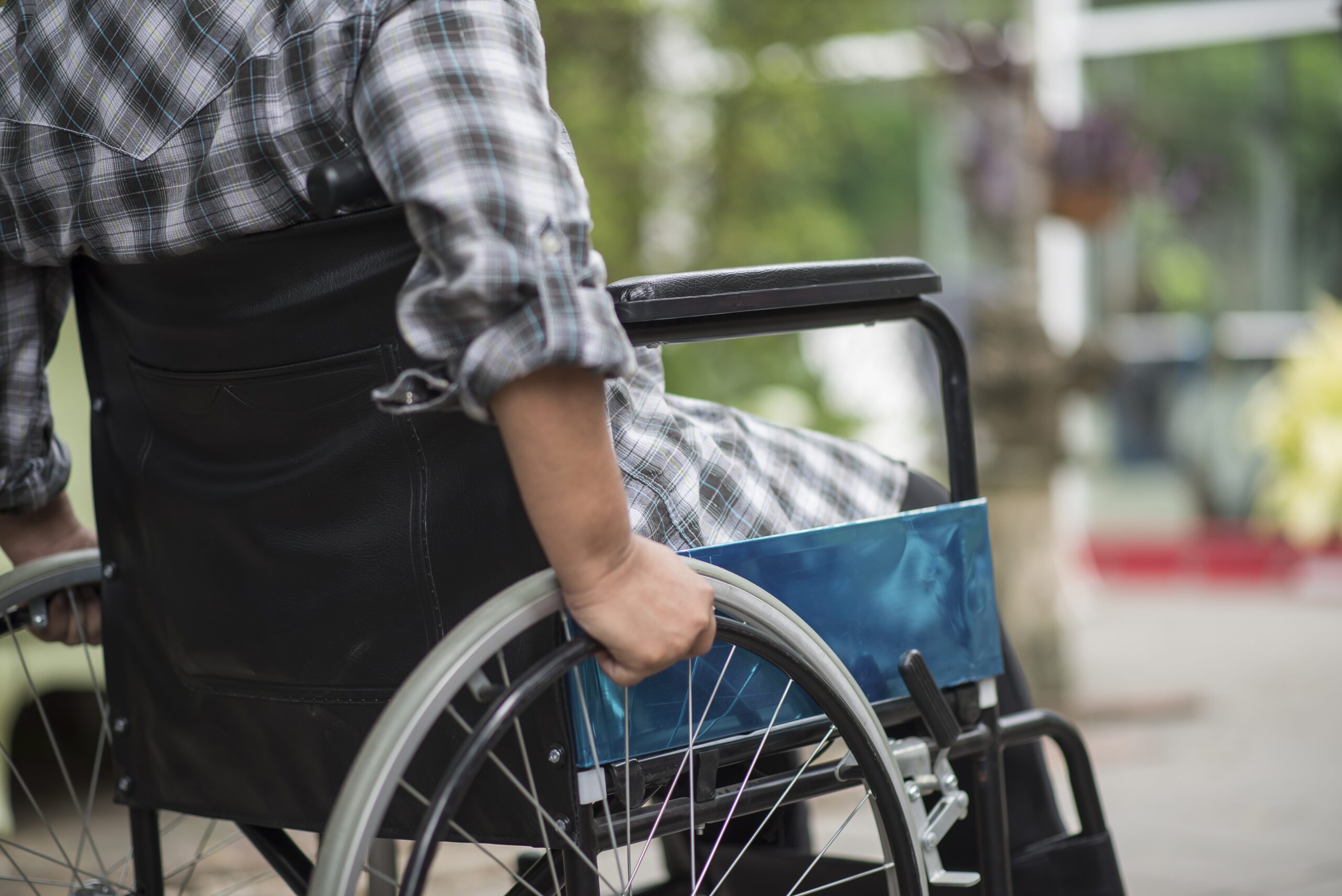 Servicios close up of senior woman hand on wheel of wheelchair during walk in hospital
